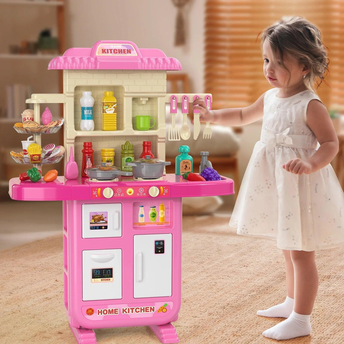 Child exploring a pink play kitchen with accessories